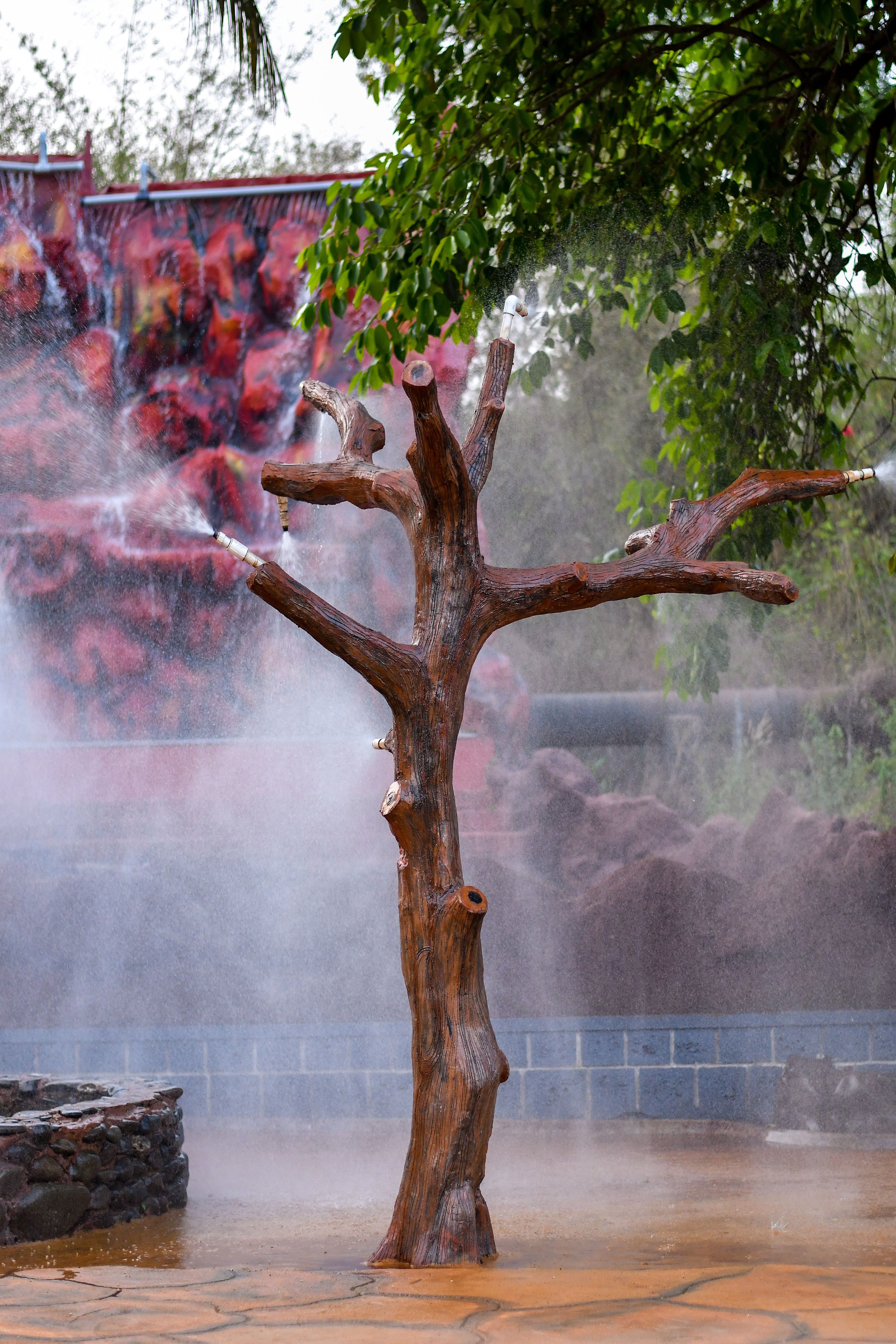 Group of visitors enjoying a refreshing water shower at Goa Aqua World, perfect for beating the heat.