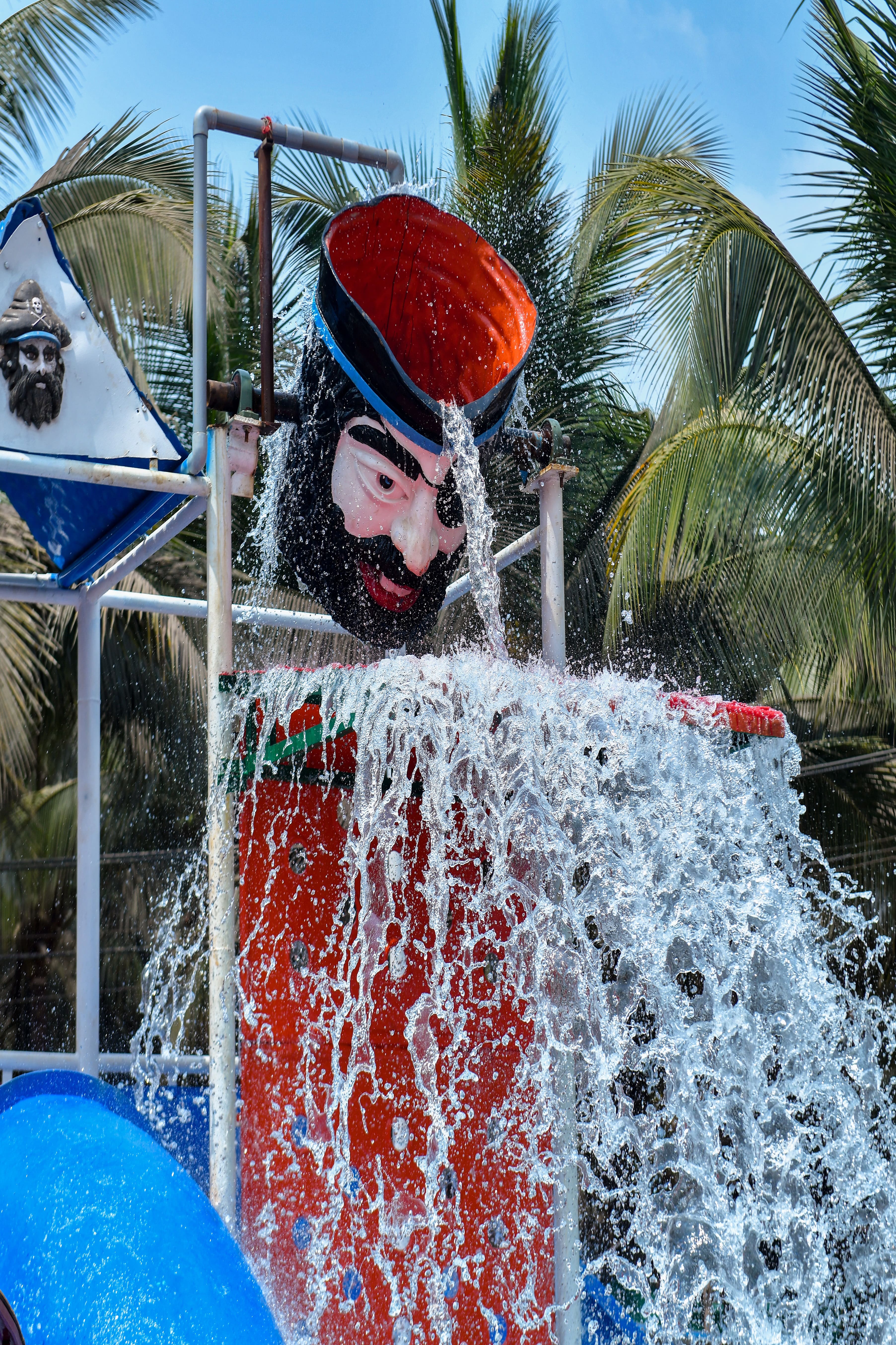 Water bucket tipping over with a splash, adding a fun element to the Goa Aqua World experience.